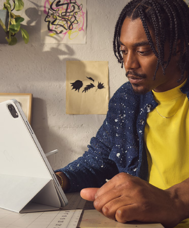 一個人正在使用 iPad Air 並搭配聰穎雙面夾，以安全的距離觀看螢幕