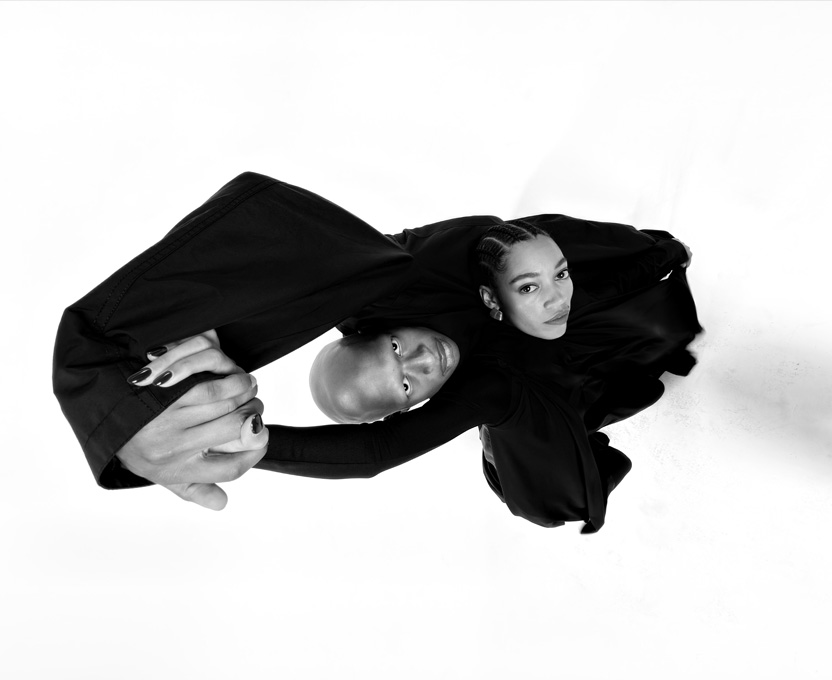 Een groothoekfoto in zwart-wit van twee personen om de mogelijkheden van de Ultragroothoekcamera van iPhone 17 Pro te demonstreren