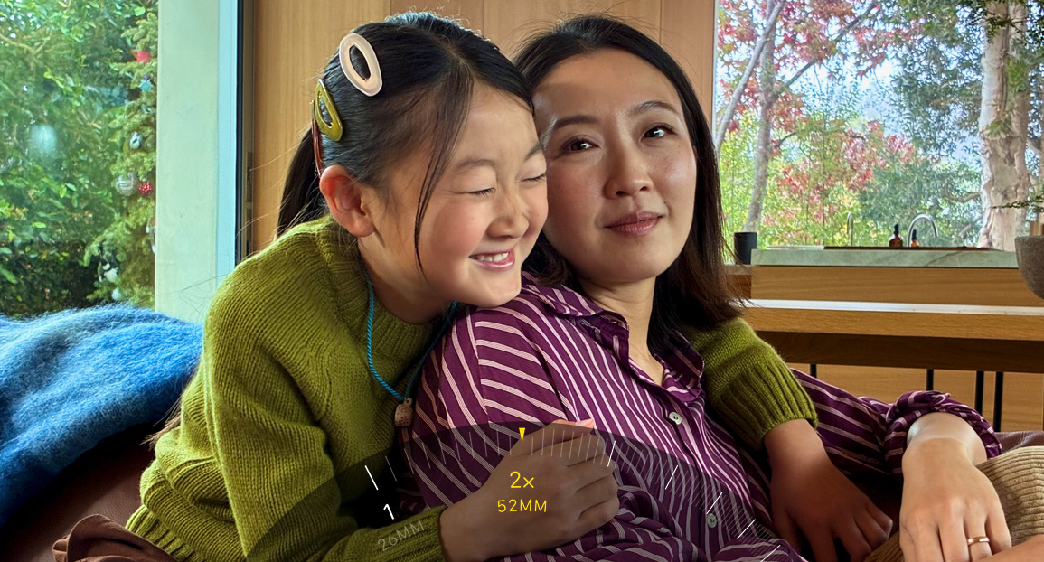 2x Telephoto feature in use, zooming in on two people hugging