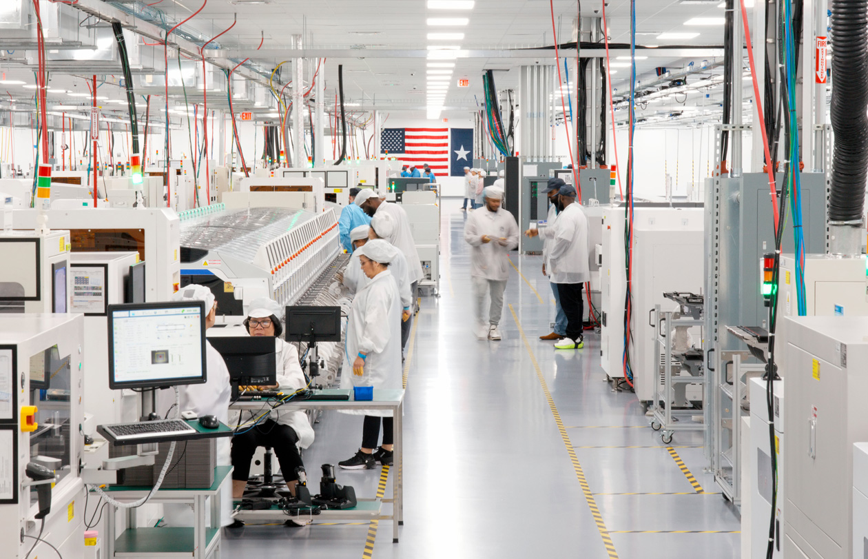 Employees in full-coverage work suits work in an AI server assembly facility